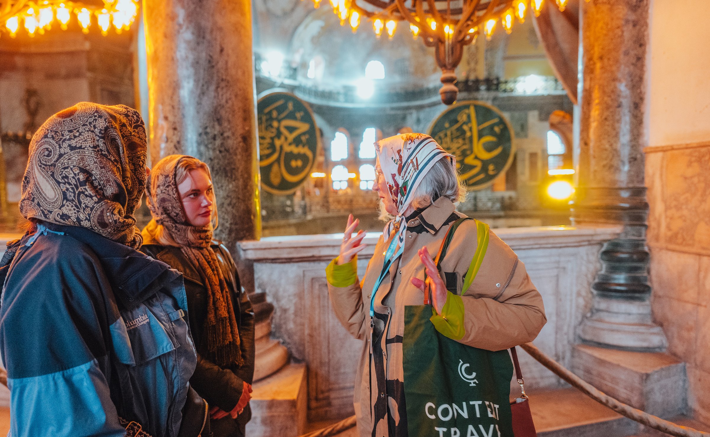Tour group in front of Islamic calligraphy roundel in the Hagia Sophia