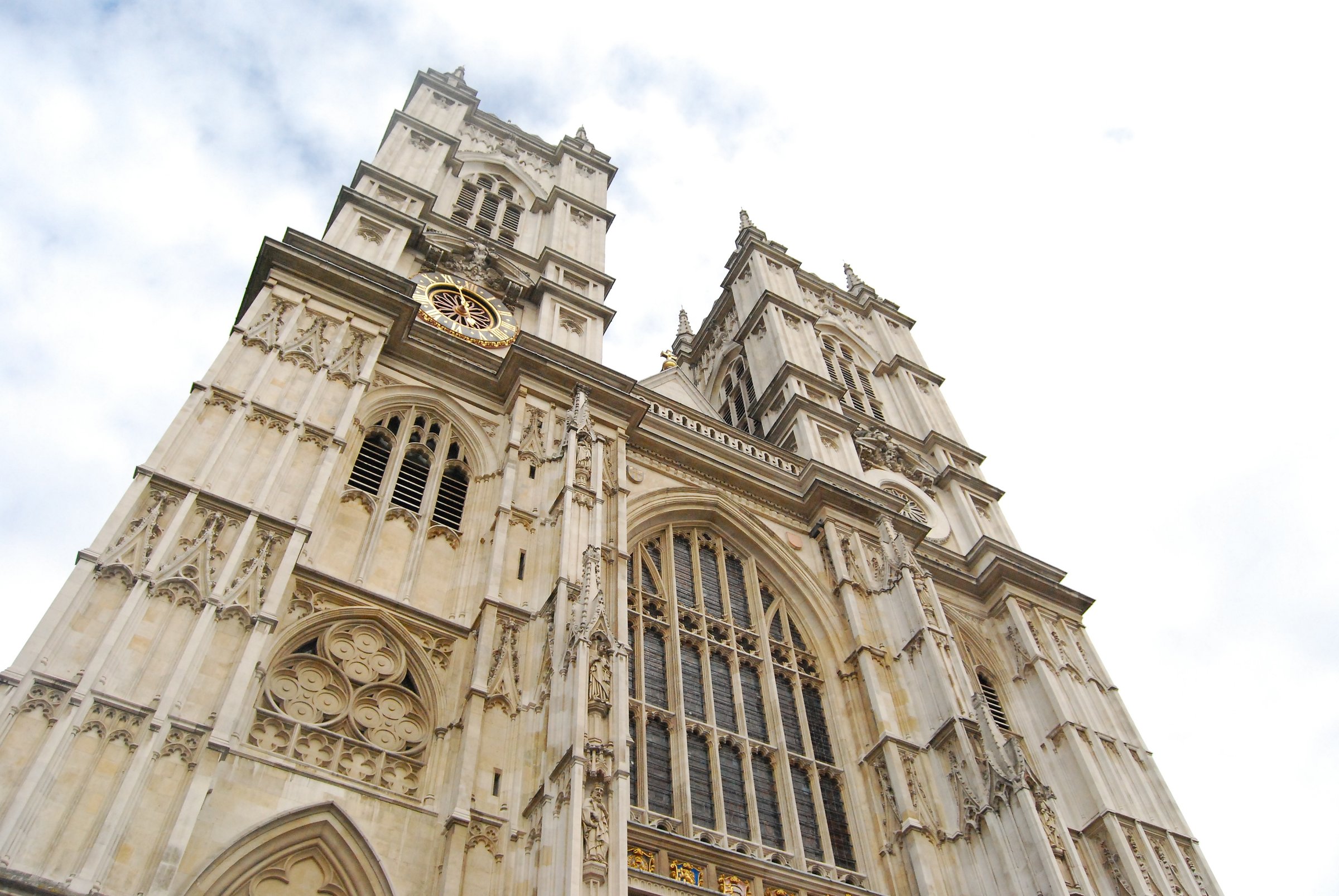 Dramatic upward view of Westminster Abbey's twin towers and ornate Gothic façade.