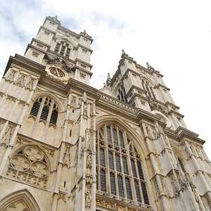Dramatic upward view of Westminster Abbey's twin towers and ornate Gothic façade.
