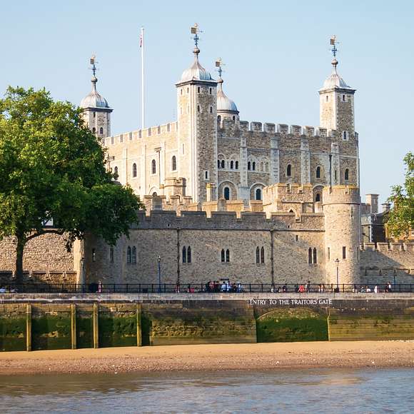 View of the Tower of London from across the River Thames, with "Entry to the Traitor's Gate" visible along the stone wall.