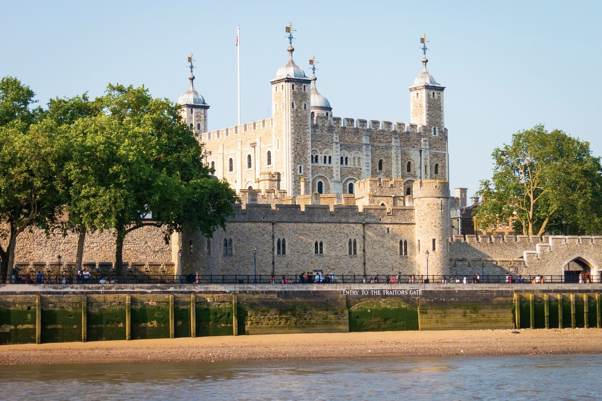 View of the Tower of London from across the River Thames, with "Entry to the Traitor's Gate" visible along the stone wall.