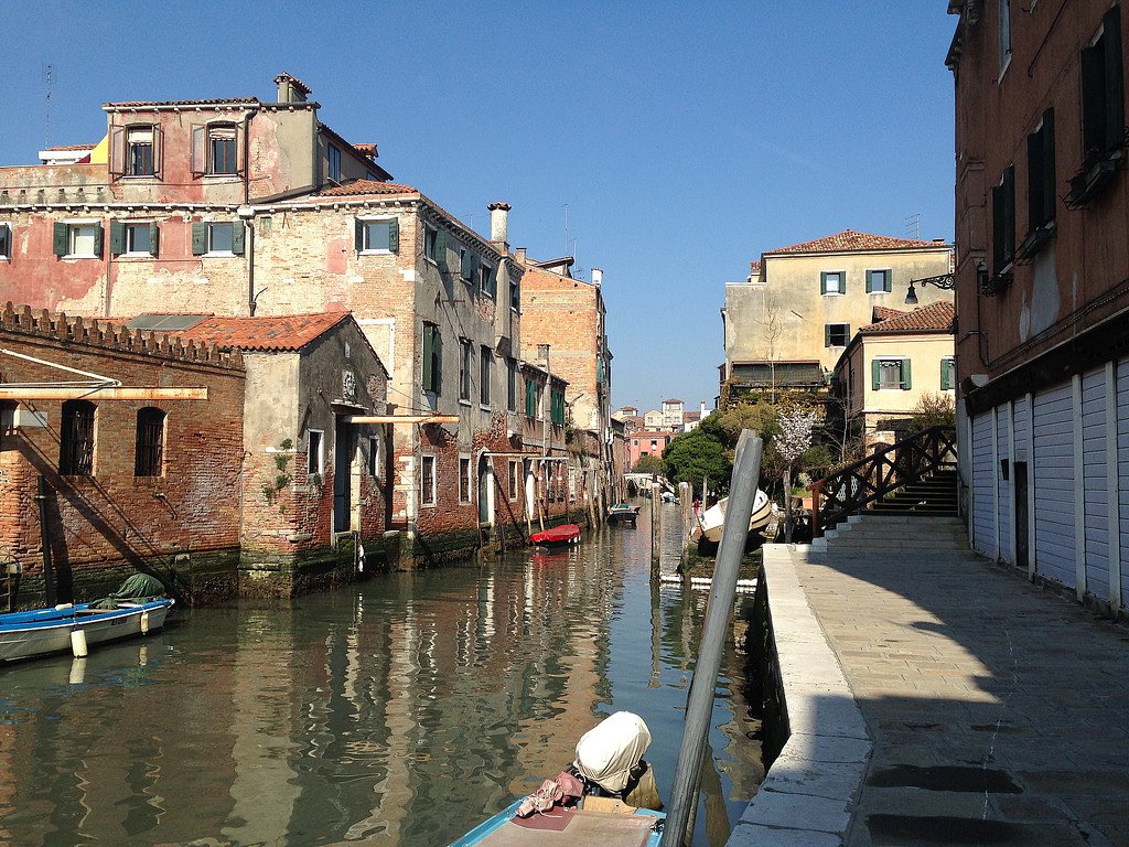 A peaceful residential canal winds through Cannaregio’s brick and pastel buildings.